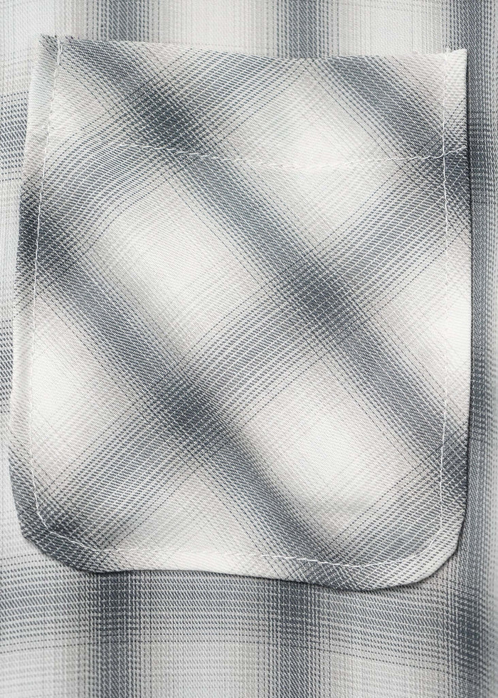 Close-up of the pocket on a monotone plaid button-up shirt showcasing its texture and design details.