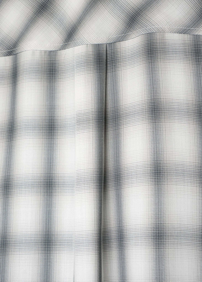 Close-up of the fabric pattern of the monotone plaid button-up shirt in soft cotton with a modern aesthetic.