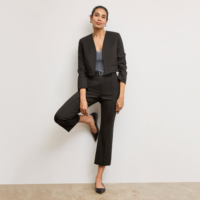 Front image of a woman standing wearing the Neale jacket in black