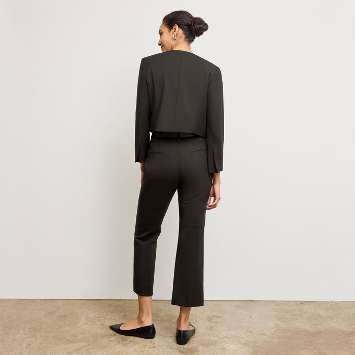 Front image of a woman standing wearing the Neale jacket in black