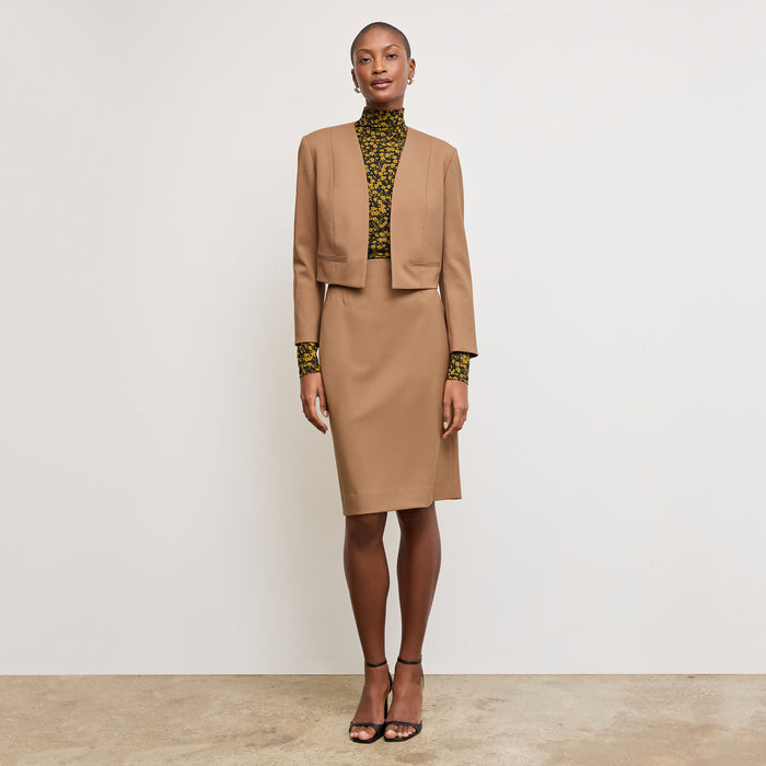 Front image of a woman standing wearing the Neale jacket in camel | Exclude