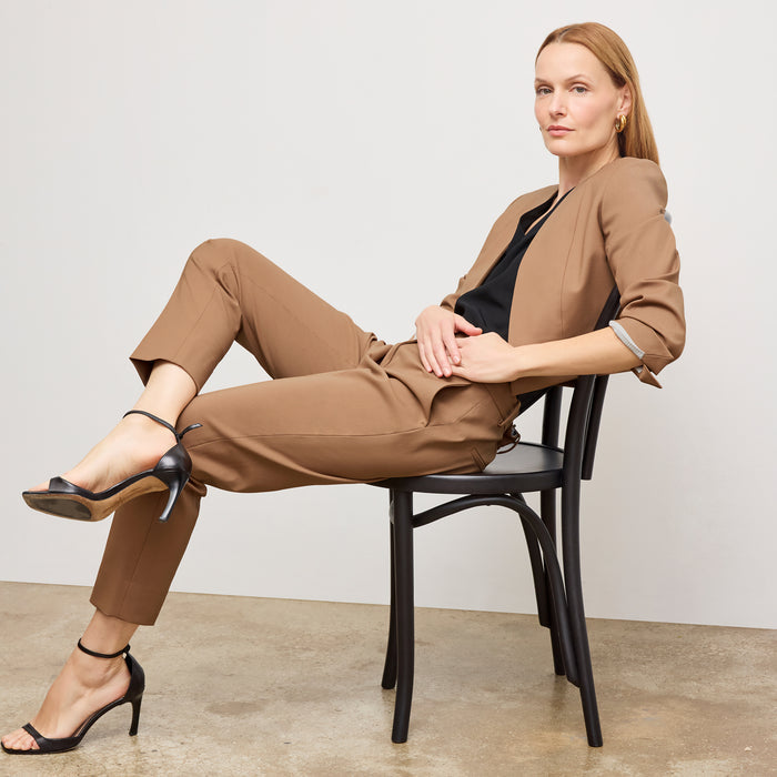 Front image of a woman standing wearing the Neale jacket in camel