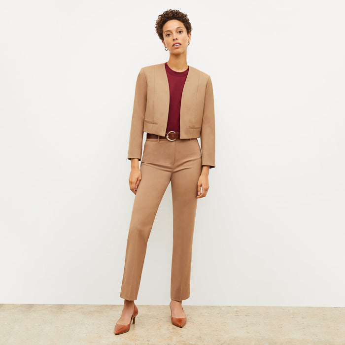 Front image of a woman standing wearing the Neale jacket in camel
