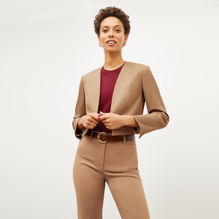 Front image of a woman standing wearing the Neale jacket in camel | Exclude