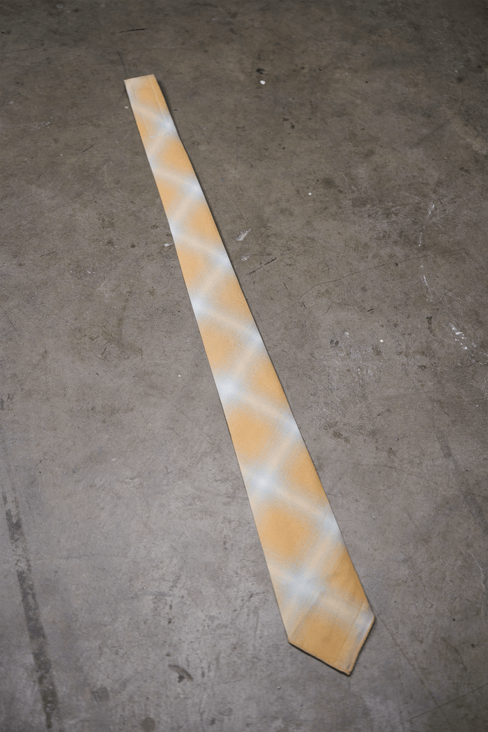 Yellow ombre plaid tie with woven finish, angled view