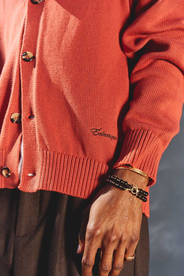 Orange v neck cardigan in Sunburst shown on male model with sleeve detail