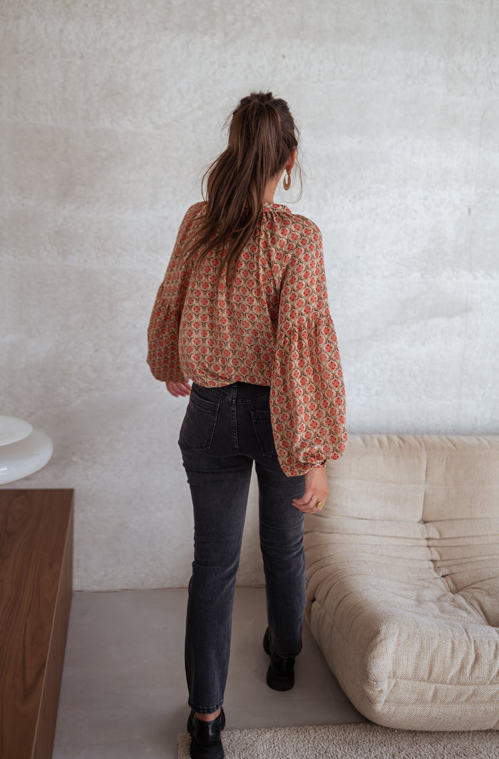 Model wearing patterned Tiffany blouse