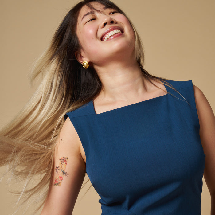 mood image of a woman wearing the pauline dress in deep teal