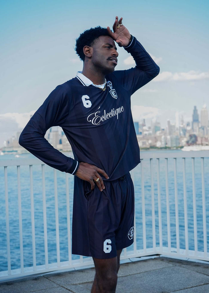 Man wearing Performance soccer shorts and a matching jersey against a city skyline backdrop.