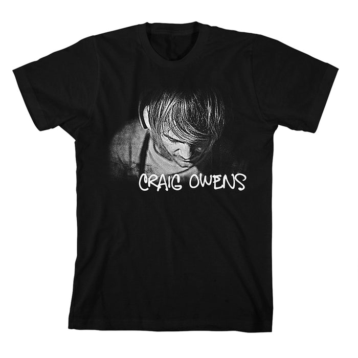 Black Craig Owens T-shirt showcasing a grayscale person with bowed head and hair partly covering their face; below the image, CRAIG OWENS appears in a white handwritten font.