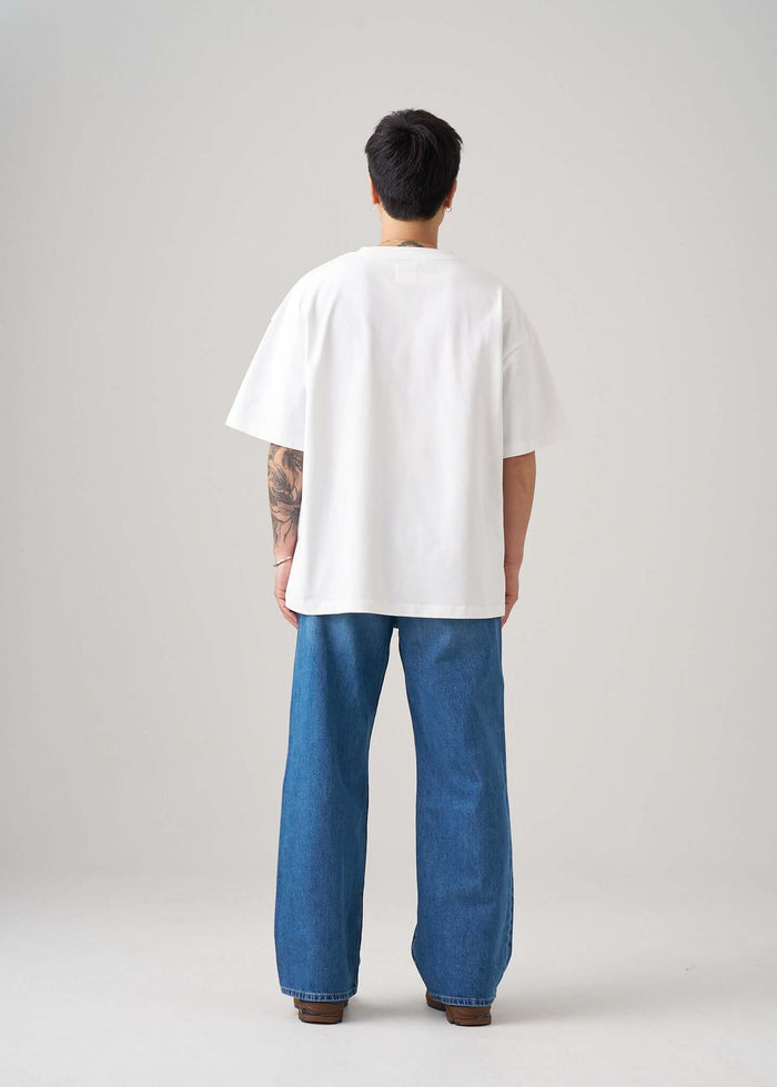 Back view of a model wearing a Racing Graphic T-shirt and wide-leg jeans, showcasing a relaxed fit and style.