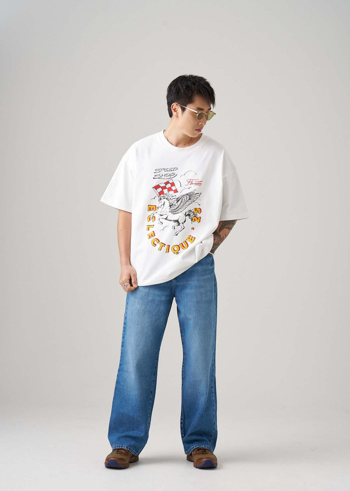 Model wearing a Racing Graphic T-shirt from Éclectique Speed Shop with relaxed fit and denim jeans.