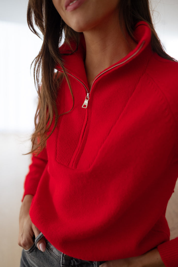 Woman wearing red half-zip sweater