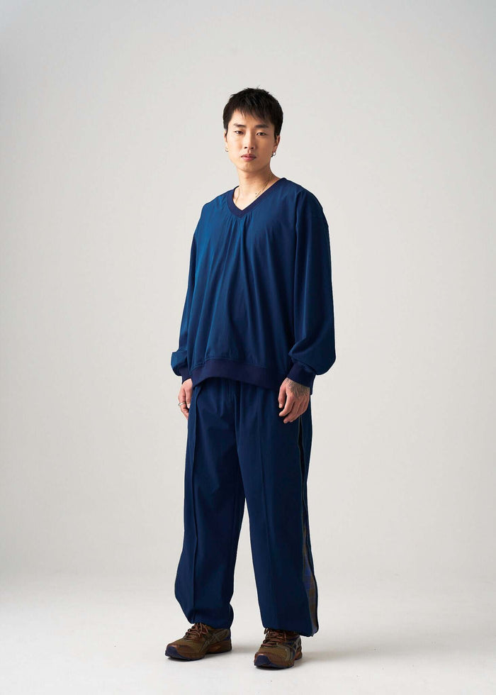 Reversible windbreaker jacket shown on model from a slight angle, navy lightweight design
