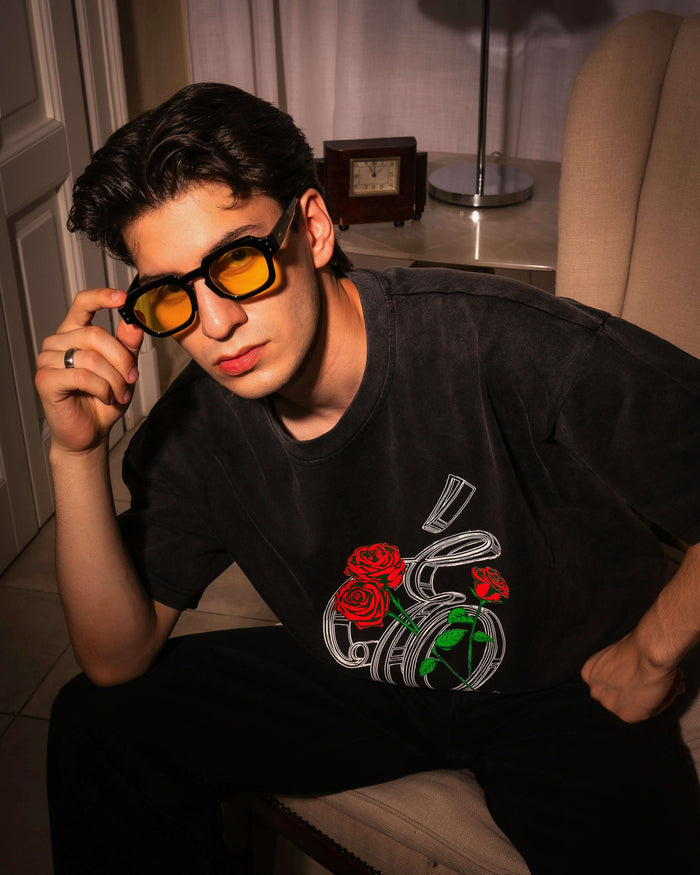 Model wearing Éclectique Rose Graphic T-Shirt with black and yellow sunglasses, showcasing detailed rose graphics.