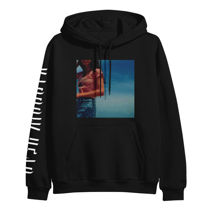 Narrow Head black hoodie made from soft ringspun cotton, showcasing a large, colorful photo print of a woman against a blue sky on the front and bold white branding down the left sleeve.