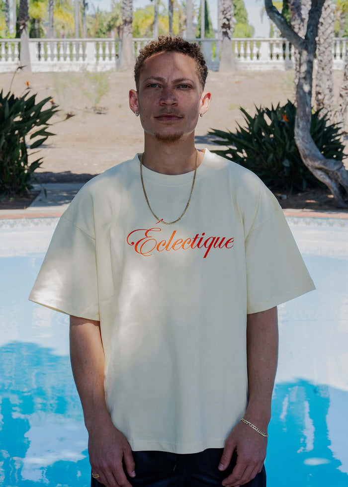 Model wearing Script Logo Embroidered Cotton T-Shirt in French Vanilla by Éclectique.