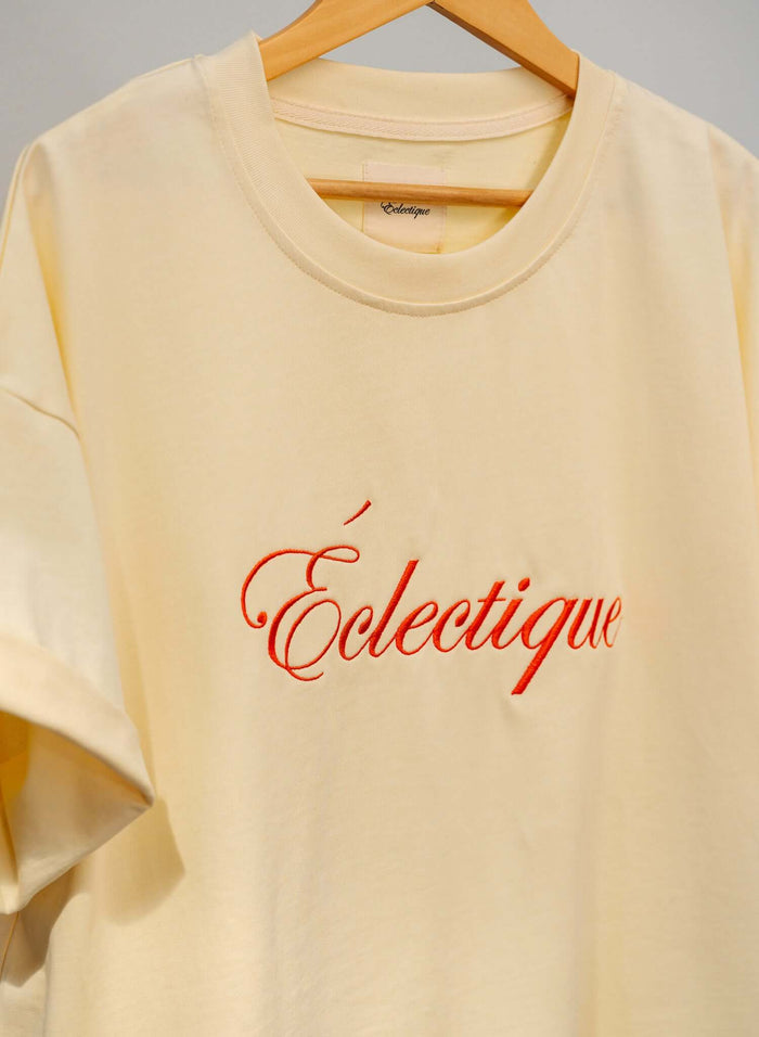 Script logo embroidered cotton t-shirt in French vanilla with Éclectique logo on chest.