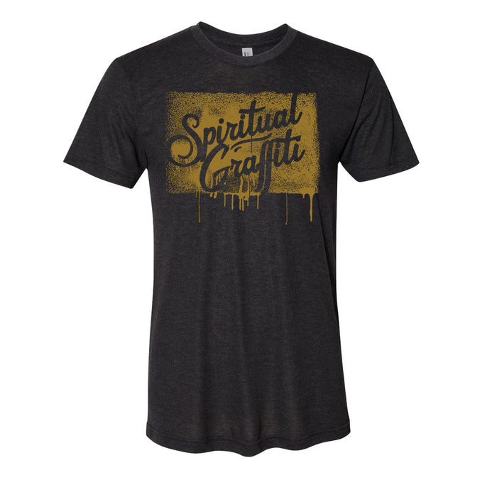 A dark gray MC YOGI t-shirt with "Spiritual Graffiti" in bold, gold spray-paint style lettering and dripping effects across the chest.