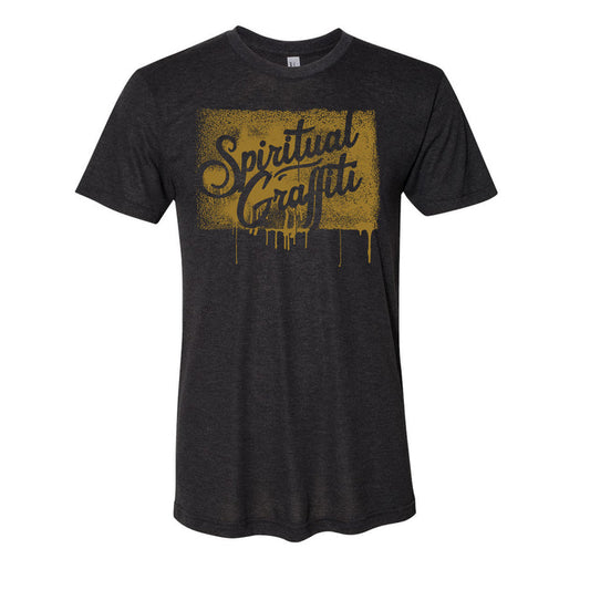 A dark gray MC YOGI t-shirt with "Spiritual Graffiti" in bold, gold spray-paint style lettering and dripping effects across the chest.