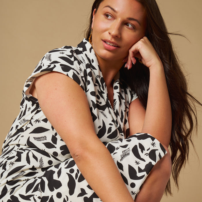 mood image of a woman kneeling wearing the tory dress in icon print