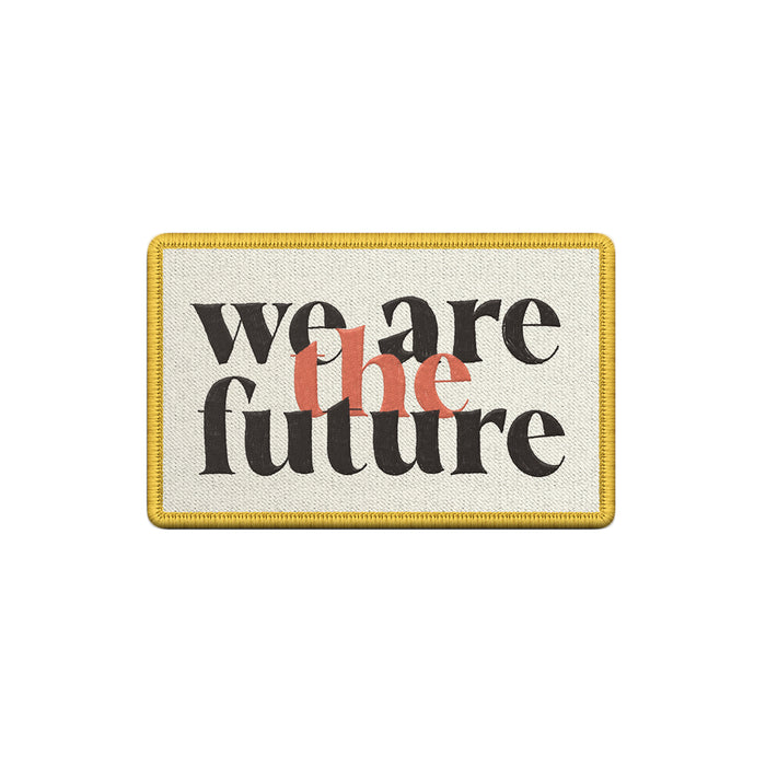 A rectangular patch by The Fall of Troy featuring a yellow border and we are the future in black and orange text on a light background.