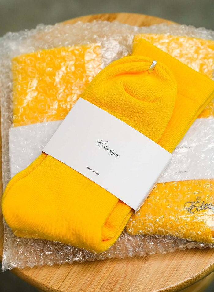 Yellow Crew socks in Spectra yellow on stool
